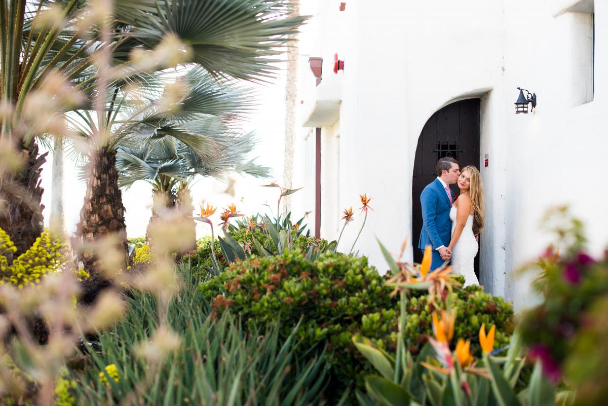 A far view of a couple holding hands under an Ole Hanson Beach Club doorway