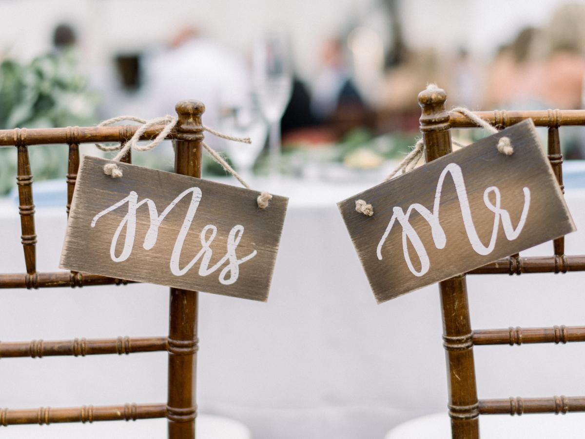 Mr. and Mrs. signs hanging on the backs of two chairs